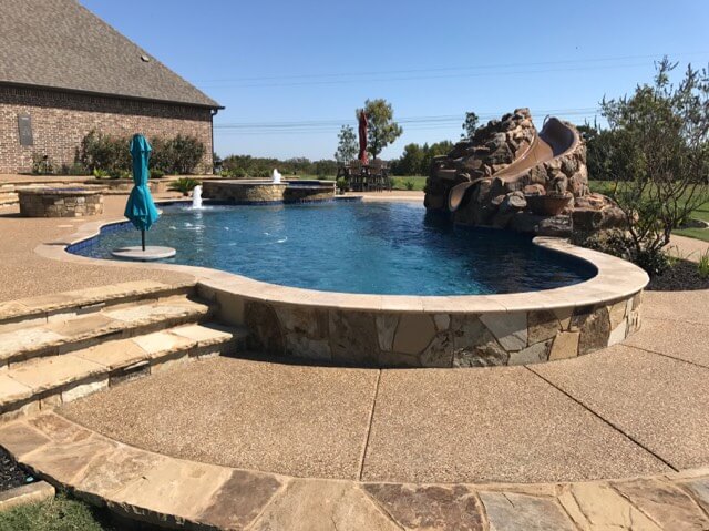 Freeform Pool with Raised Spa, Slide, Table and Firepit